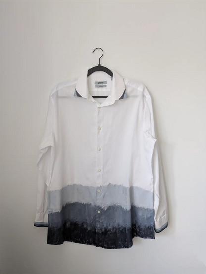 White shirt with gradient design on a hanger against a plain background