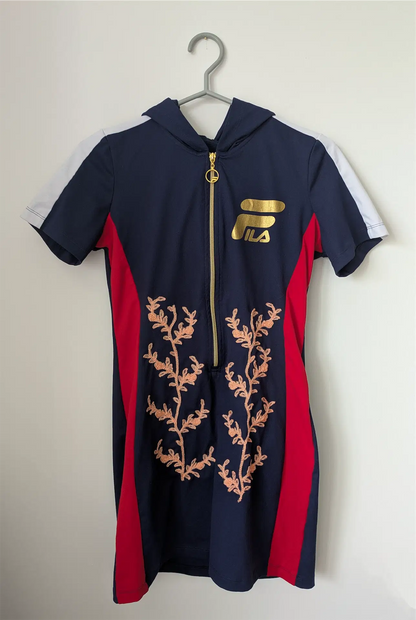 Navy and red dress with floral design and gold zipper on a hanger against a white background